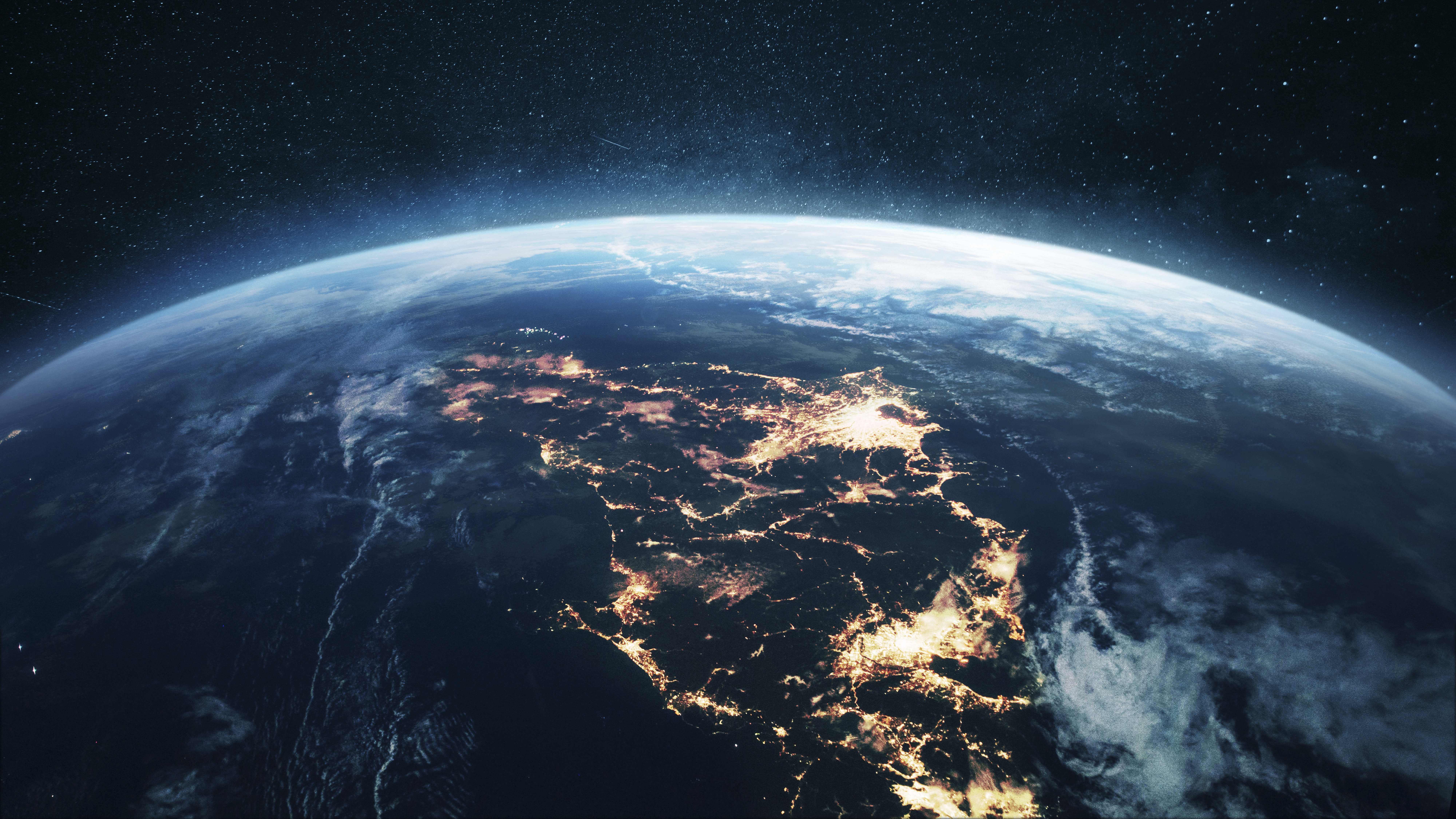 Une image de la Terre depuis l’espace. Les lumières des villes et les nuages tourbillonnants, avec le bleu sombre profond de l’océan, traduisent parfaitement la connectivité mondiale.